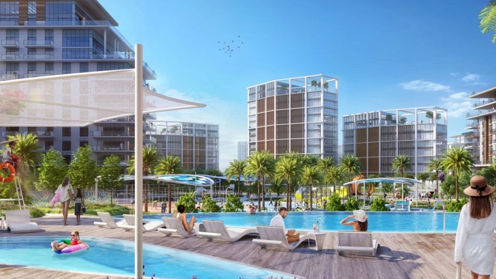 Modern resort with people relaxing by a large pool, surrounded by palm trees and contemporary buildings under a clear blue sky.