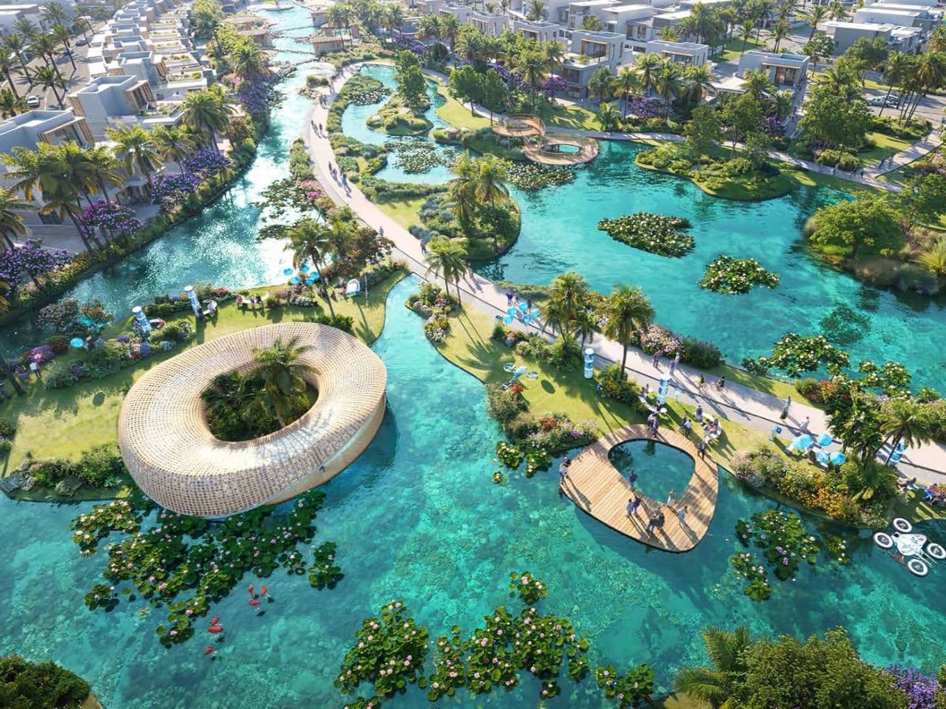 Aerial view of a tropical resort with winding waterways, lush greenery, palm trees, vibrant flowers, and unique contemporary architecture.