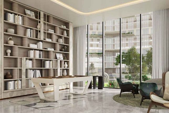 Bright modern lounge with floor-to-ceiling windows, built-in bookshelf, white game table and cozy seating overlooking a landscaped courtyard.