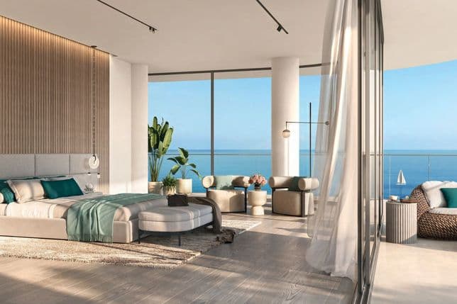 Serene master bedroom with curved floor-to-ceiling windows, minimalist furnishings, and unobstructed ocean views.