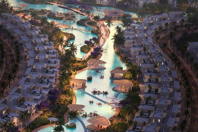 Aerial view of a luxurious resort with winding pools, palm trees, loungers, and modern villas during sunset.