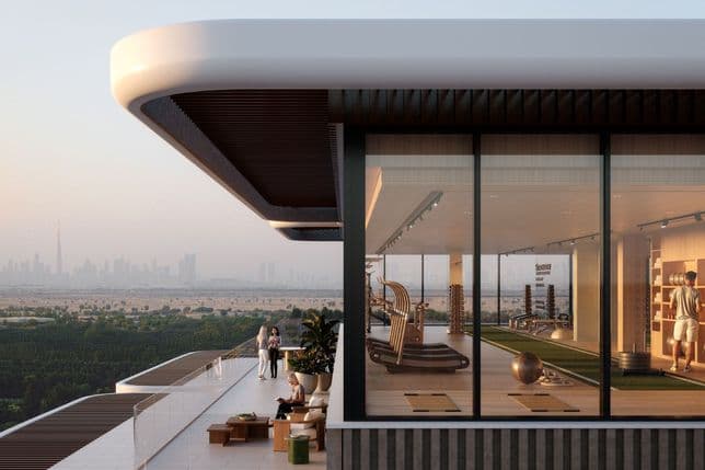 Modern rooftop gym with large windows, overlooking a city skyline and greenery. People relax on the terrace, enjoying the view.