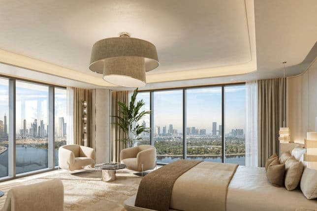 Luxurious bedroom with panoramic city views, featuring a large bed, modern furniture, a central light fixture, and floor-to-ceiling windows.