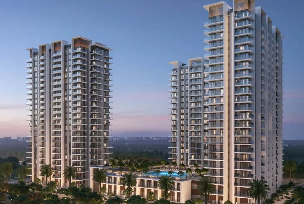 Rosehill by Emaar with balconies, surrounded by greenery and a central pool, under a clear evening sky.