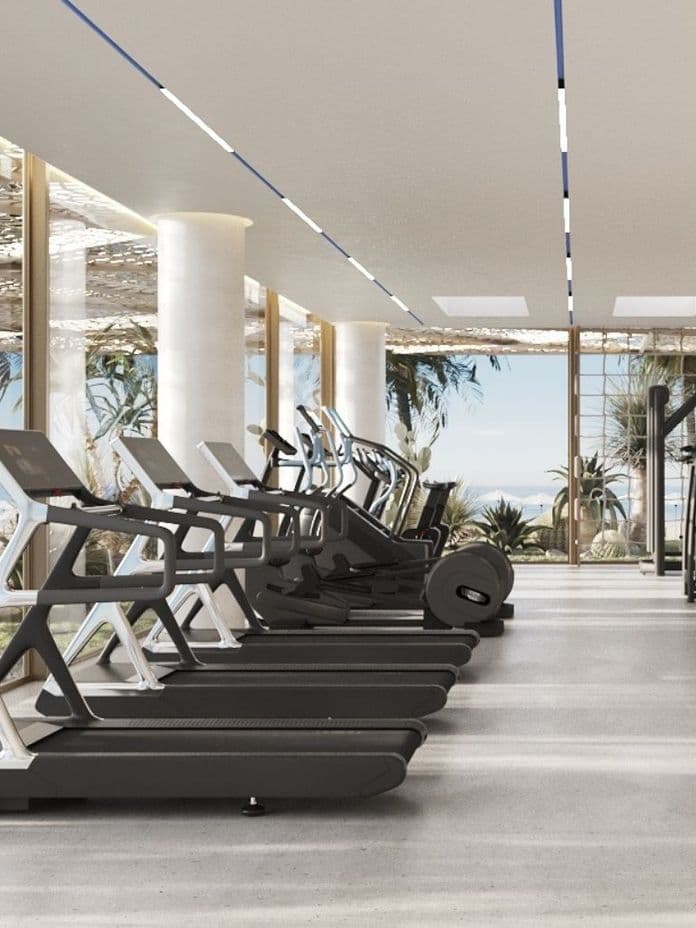 State-of-the-art gym with ocean views at Nikki Beach Residences by Aldar in RAK, featuring treadmills, free weights, and wellness amenities.