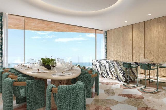 Dining area with large table, bar counter, and sea view in a beachfront apartment.