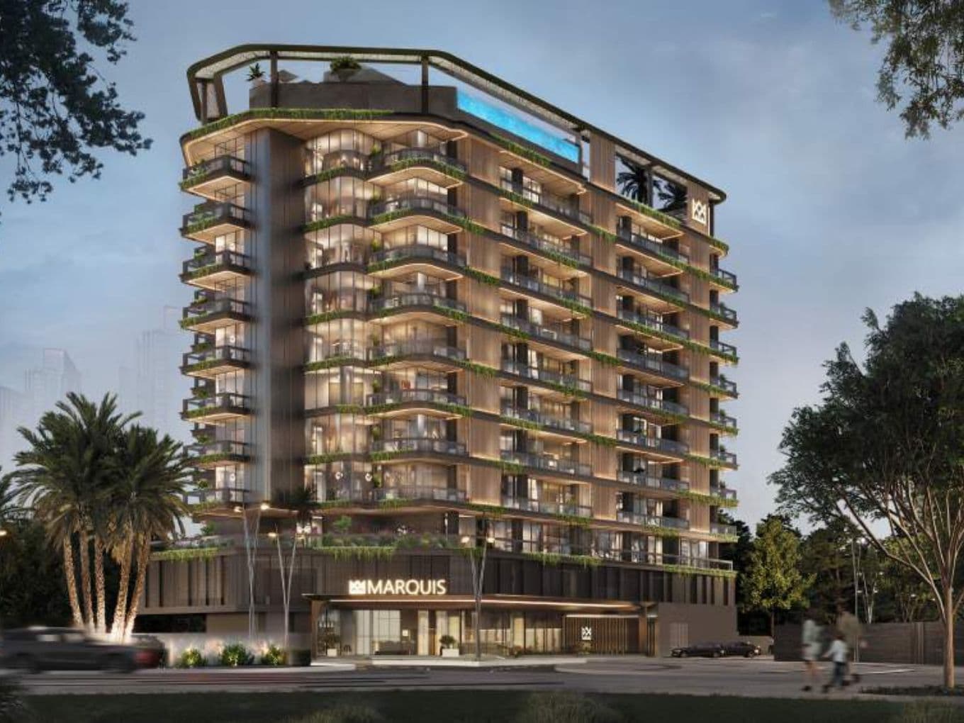 Abendliche Außenansicht von Marquis Vista im DLRC von Marquis Development mit moderner Glasfassade, umlaufenden Balkonen und beleuchteter Architektur, umgeben von viel Grün.