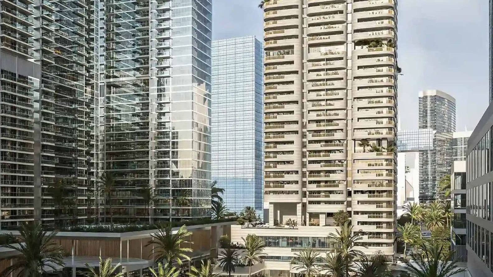 Modern cityscape with tall glass buildings, palm trees, and a sunny sky, reflecting urban design and greenery integration.