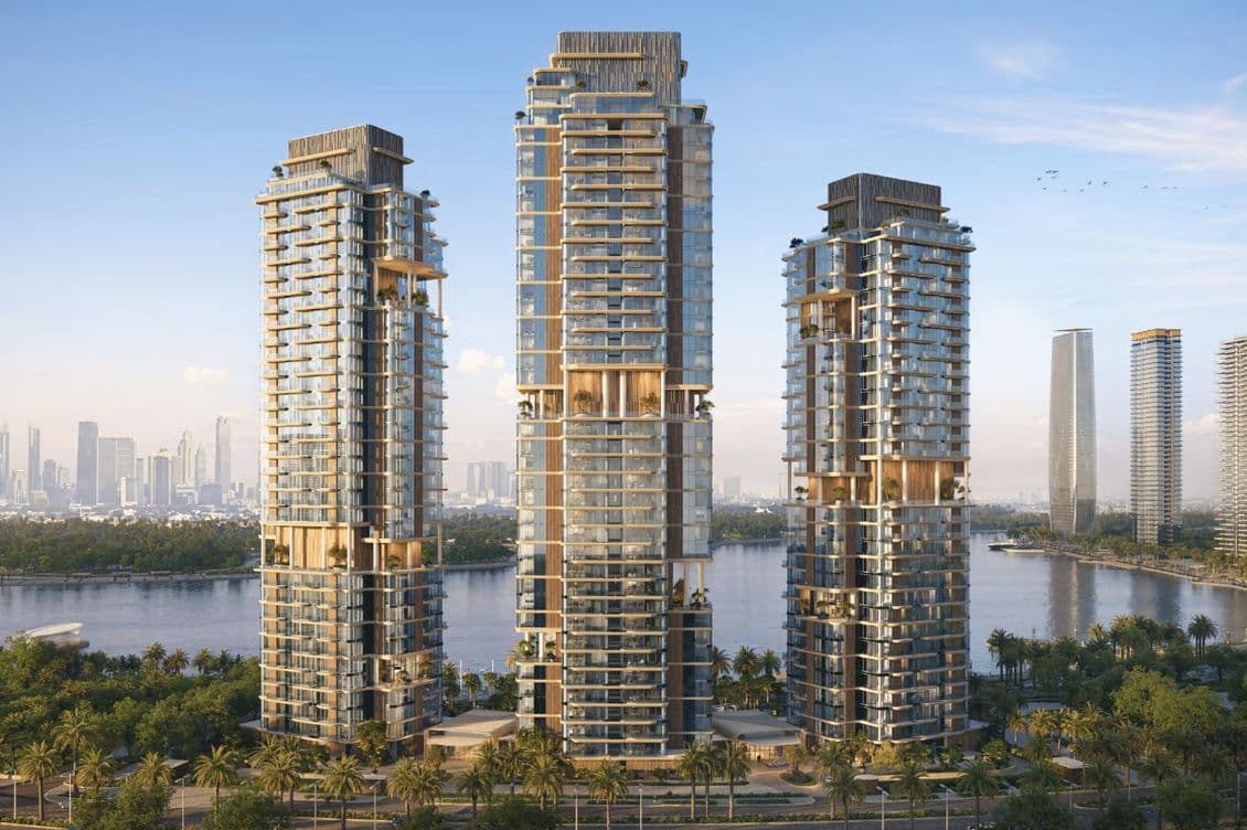 Modern towers at Dubai Design District with landscaped waterfront pathways under a clear sky.