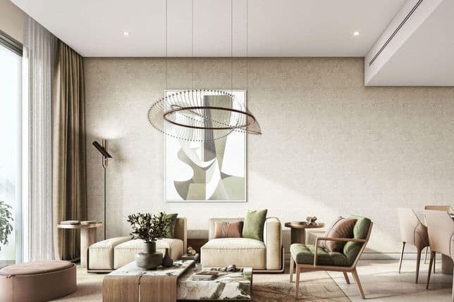 Modern living room with beige sofas, green pillows, abstract art, and unique pendant light. Elegant decor with plants and round tables.