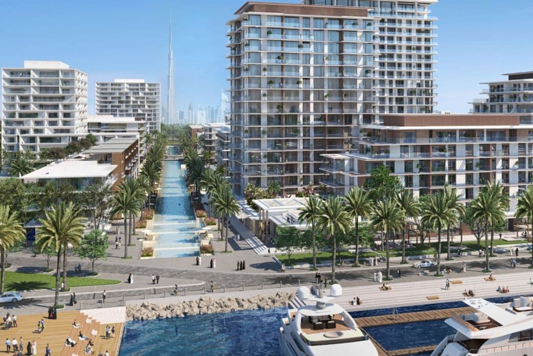 View of Mina Rashid waterfront with luxury yachts docked in the foreground, palm-lined promenades, modern mid-rise residential buildings, and a central water feature leading toward the Burj Khalifa visible in the distant skyline.          Ask ChatGPT