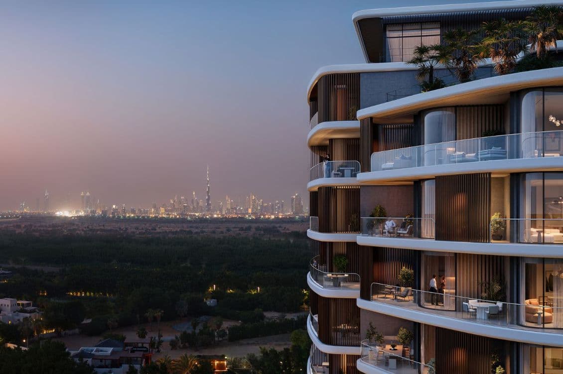 Modern high-rise with curved balconies overlooking a lush landscape and distant city skyline at dusk, featuring a prominent tower.