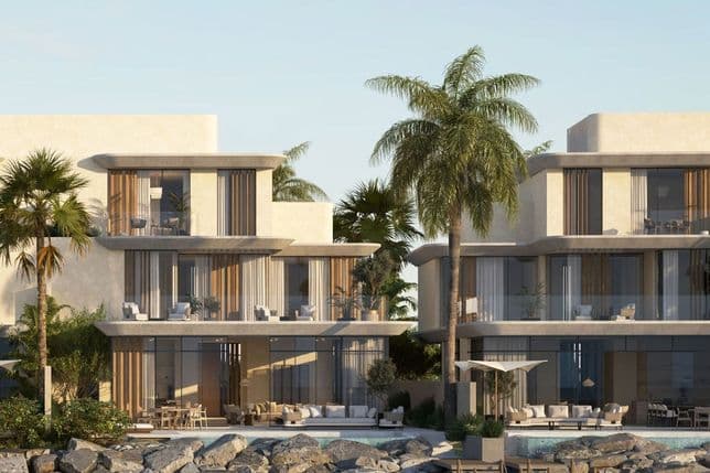 Full-frontal view of Anantara villas with palm trees, large balconies, and private dock access.