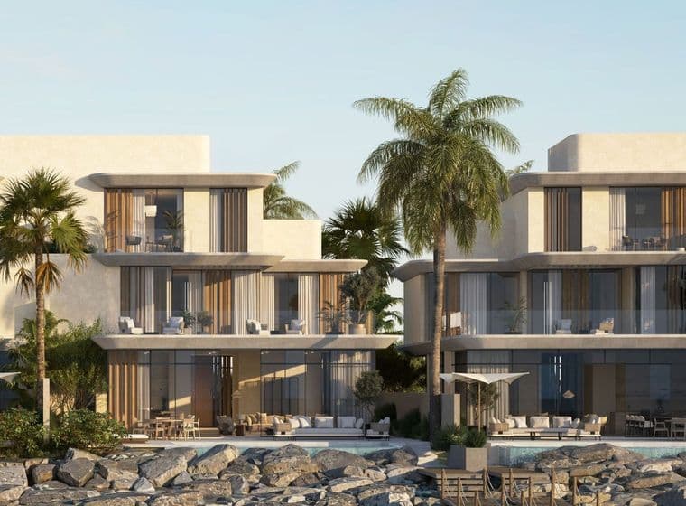 Full-frontal view of Anantara villas with palm trees, large balconies, and private dock access.