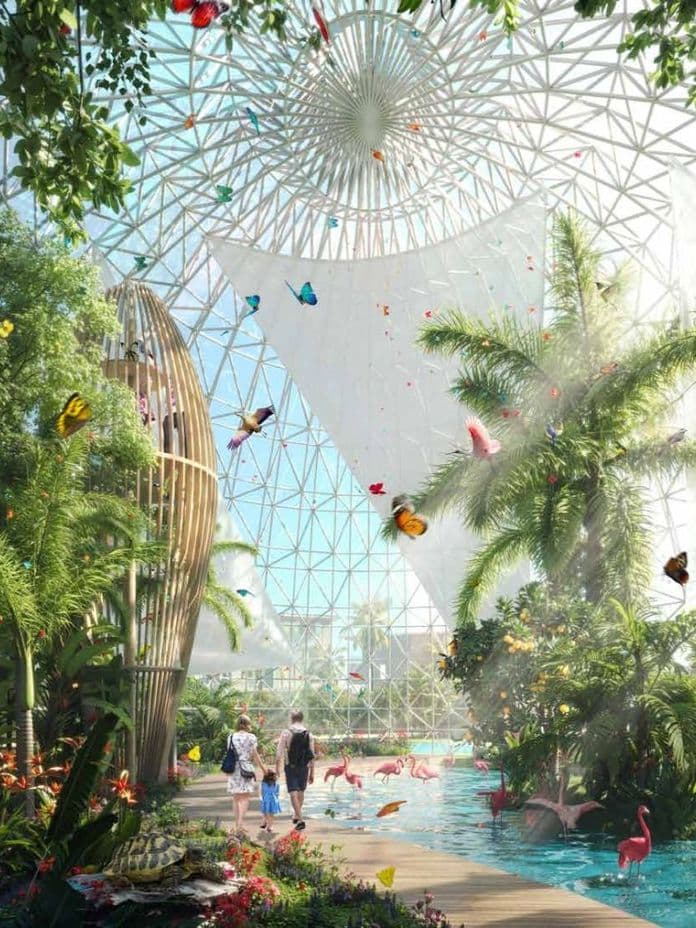 A lush tropical indoor garden with a glass dome, flamingos in a pond, vibrant butterflies, and people walking on a path.