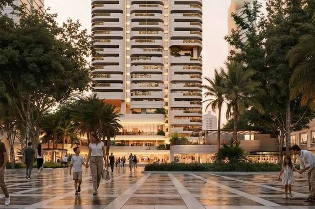 Modern plaza with people walking, lined by trees and palm trees. A tall building with unique horizontal lines stands prominently in the background.