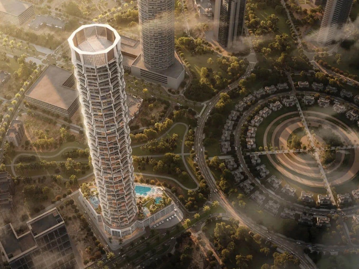 Luftaufnahme eines hohen, modernen Wolkenkratzers – Binghatti Circle – mit einzigartigem geometrischem Design, umgeben von Grünflächen und kreisförmigen Strukturen in einer urbanen Umgebung.