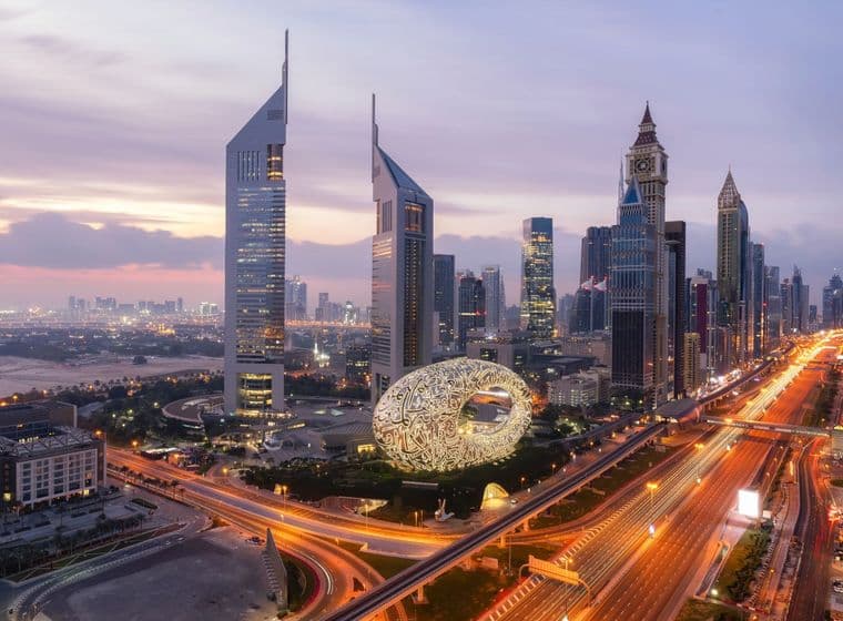 High-rise skyline of DIFC at sunset, with bright lights down Sheikh Zayed Road
