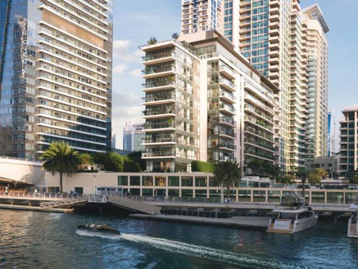 Waterfront view of Residences Du Port building with yachts docked in front and modern high-rises behind.