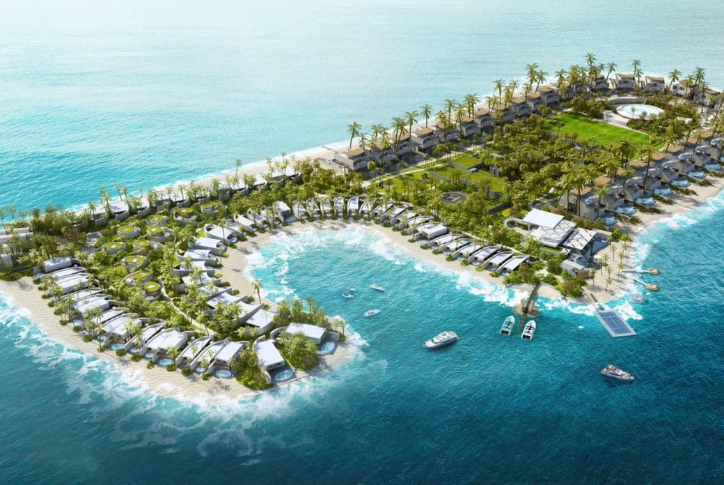 Aerial view of Zuhha Island resort with villas, palm trees, boats, and clear blue ocean waters.