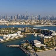 ariel view of jumeirah bay island with dubai skyline