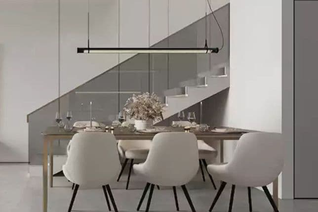 Moderner Essbereich mit weißen Stühlen, linearer Hängebeleuchtung und einer Treppe mit Glasgeländer.