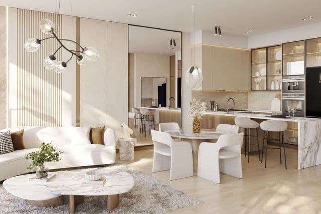 Modern open-plan living and kitchen space with a white sofa, marble tables, chic lighting, and neutral decor elements.