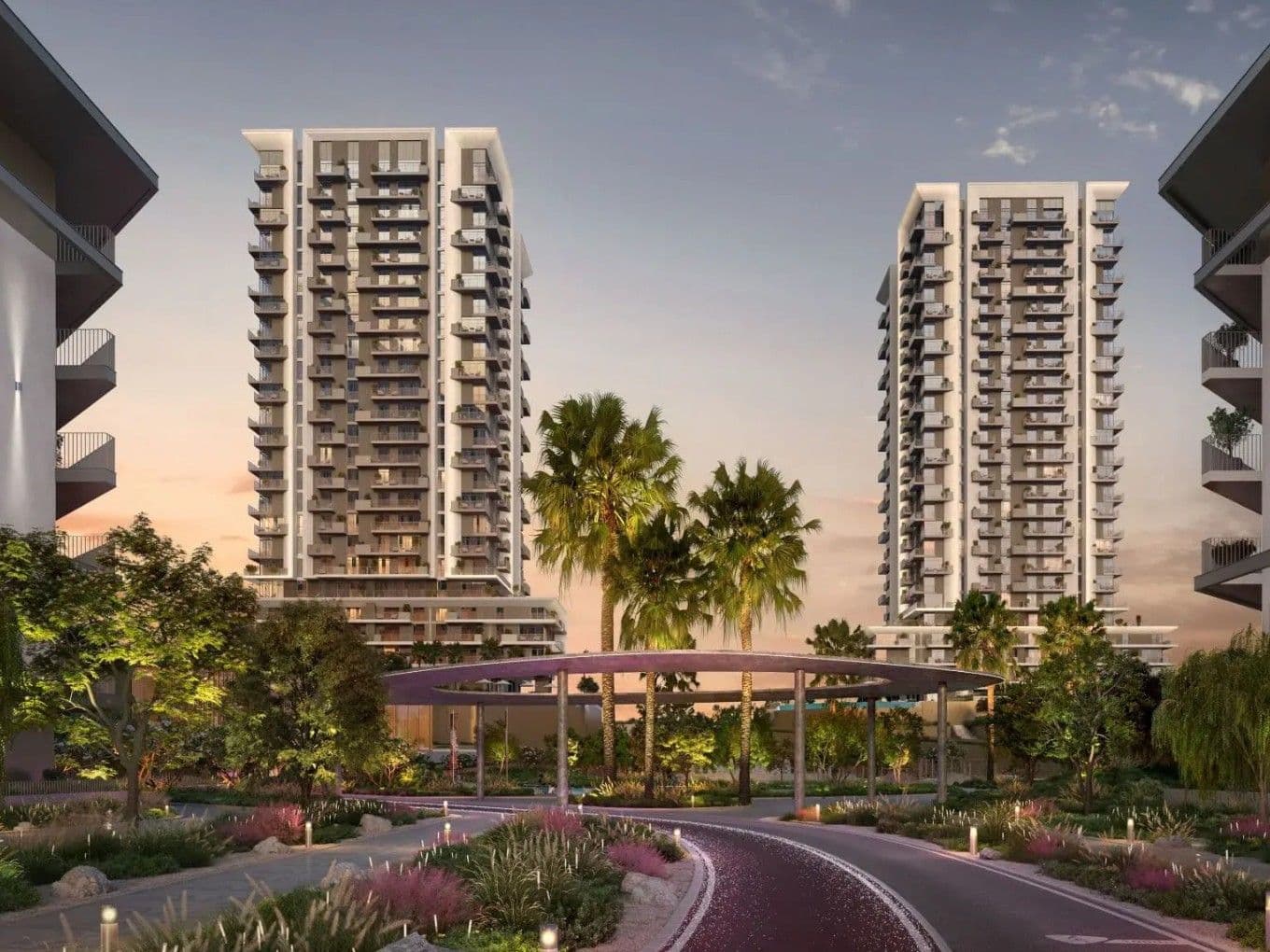 Modern residential towers at Athlon with balconies, surrounded by lush greenery and palm trees, under a twilight sky. Curved pathway in the foreground.