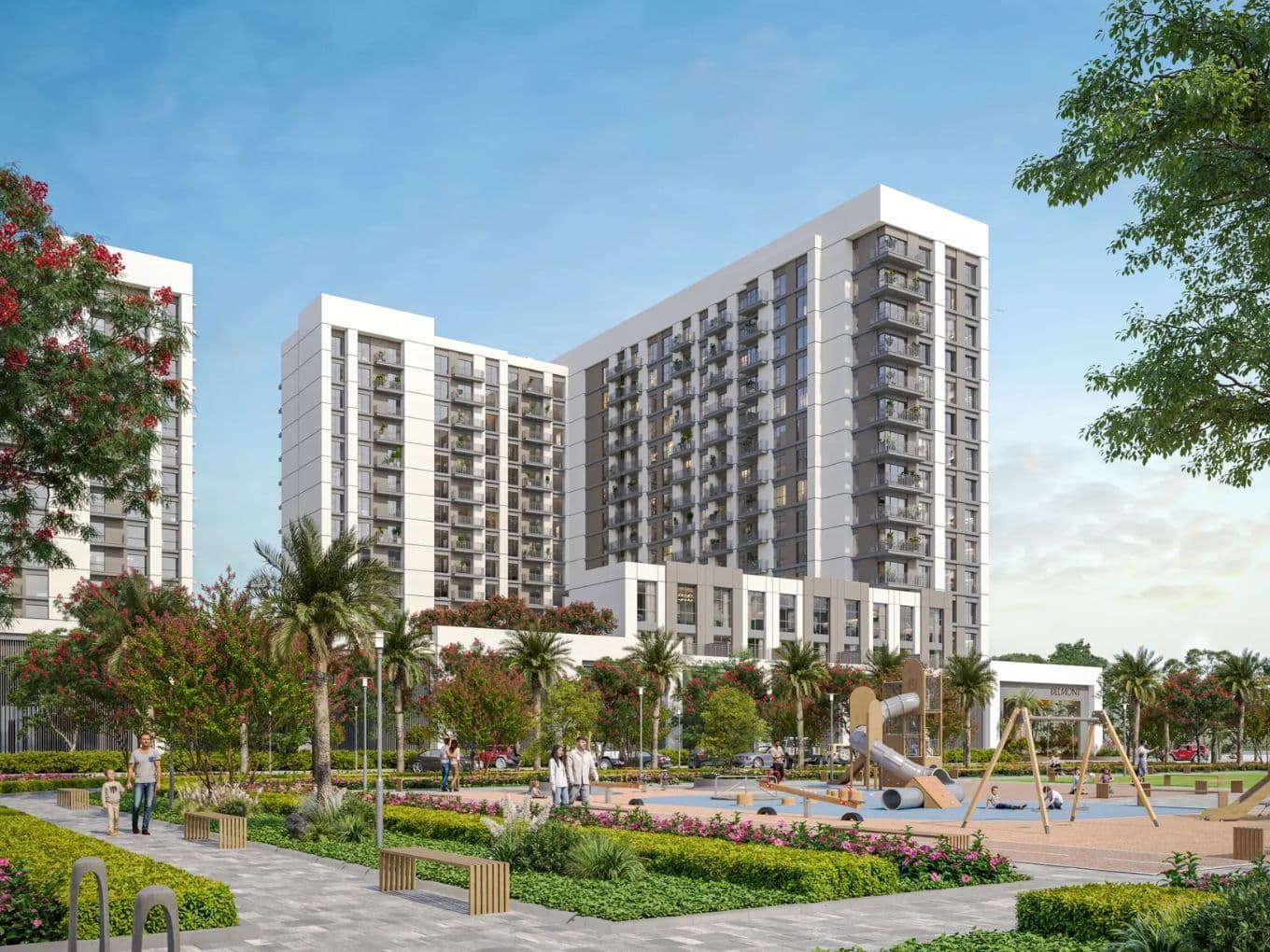 Modern apartment complex with two tall buildings, surrounded by greenery. A playground with swings and slides is in the foreground under a blue sky.