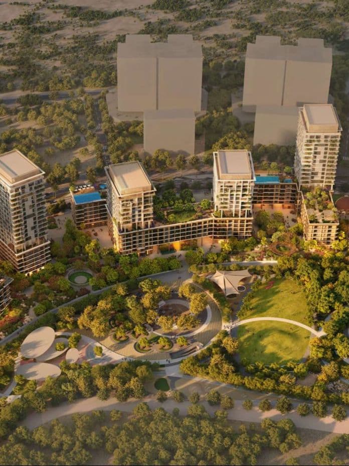 Aerial view of a sunlit residential complex: several high‑rise towers with rooftop pools set amid landscaped parklands and winding pathways.