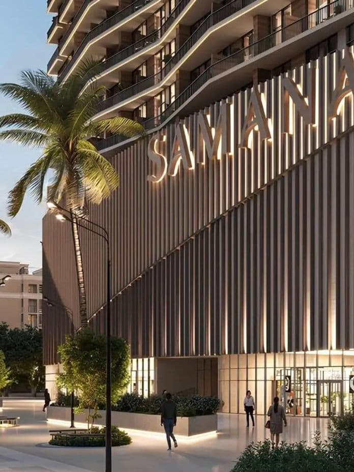 Modern building facade with "Samana" sign, people walking, palm trees, and warm lighting creating an inviting urban atmosphere.