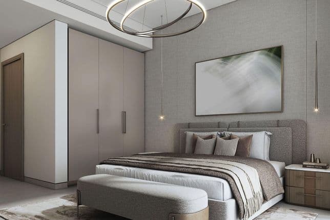 Modern bedroom with a gray upholstered bed, layered bedding, abstract artwork, sleek pendant lights, and a large closet.