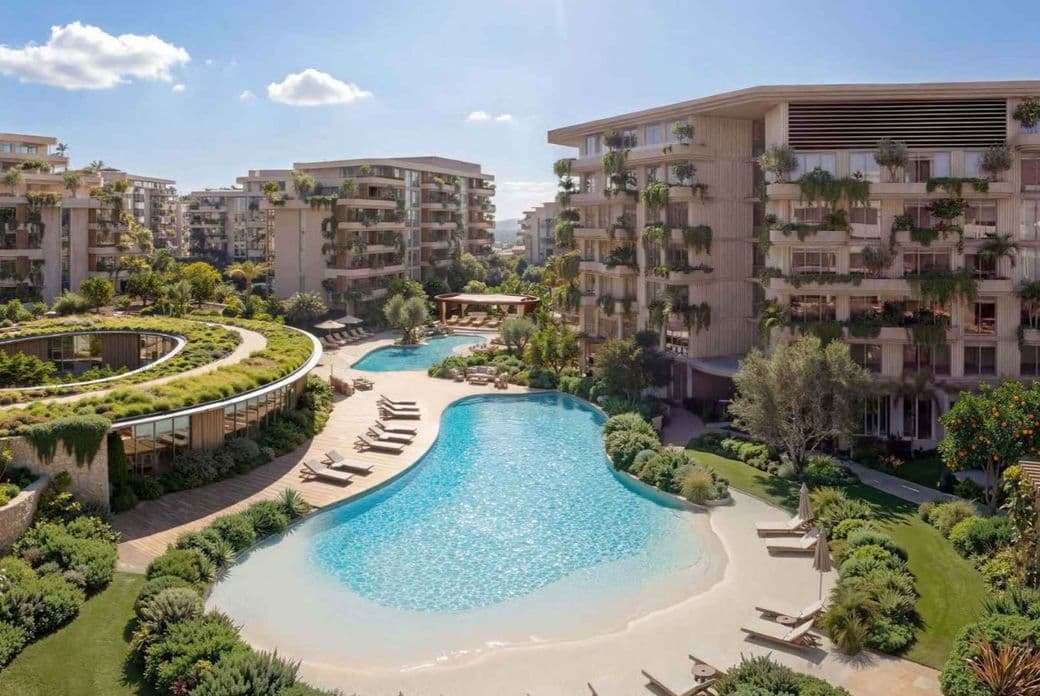 Modern apartment complex with lagoon-style pool, sandy beach edge, lounge chairs and lush landscaping