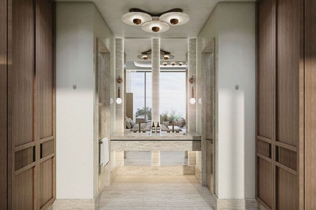 Elegant hallway with wooden paneling, stone details, pendant lights, and a large mirror reflecting a bright, airy room with a view.