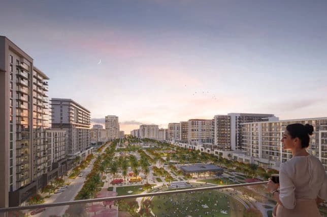 Woman on balcony overlooking a modern urban park surrounded by high-rise buildings at sunset, with a crescent moon in the sky.