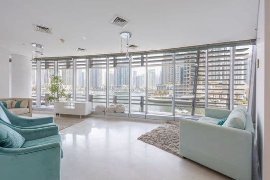 High-rise perspective from Cayan Tower in Dubai showcasing marina waterfront, luxury yachts, and surrounding residential towers.