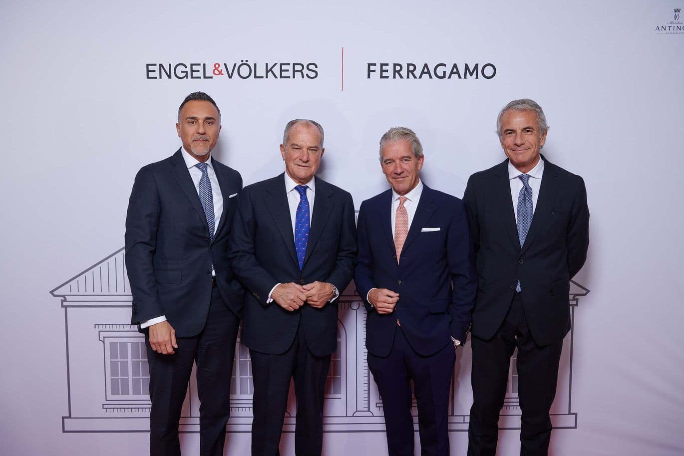 Four men in suits stand in front of a backdrop with "Engel & Völkers" and "Ferragamo" logos.
