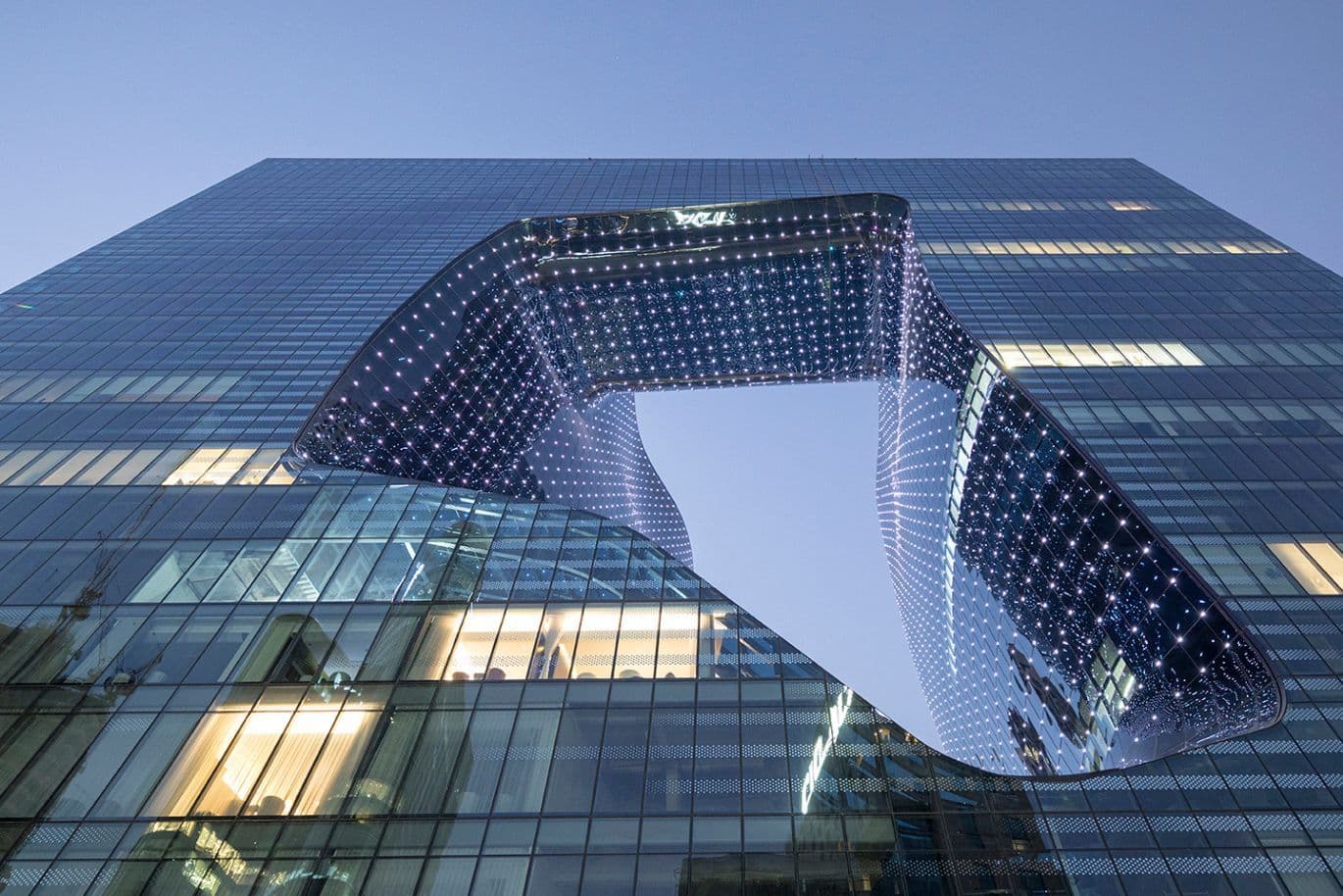 Architectural marvel by Zaha Hadid, The Opus, in Business Bay with fluid curving lines and glass exterior