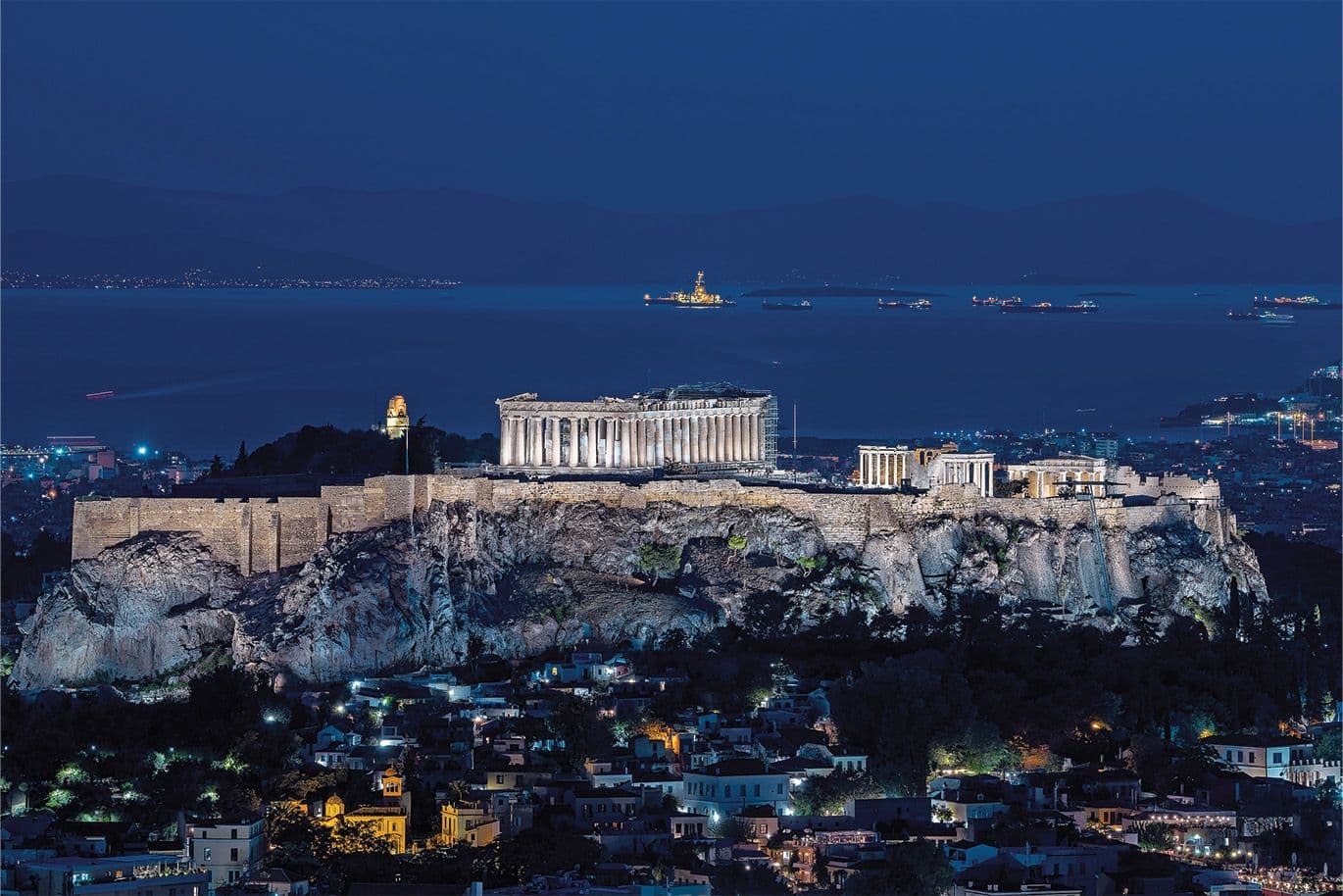 Νυχτερινός φωτισμός της Ακρόπολης και του Παρθενώνα στην Αθήνα με θέα τον Σαρωνικό.
