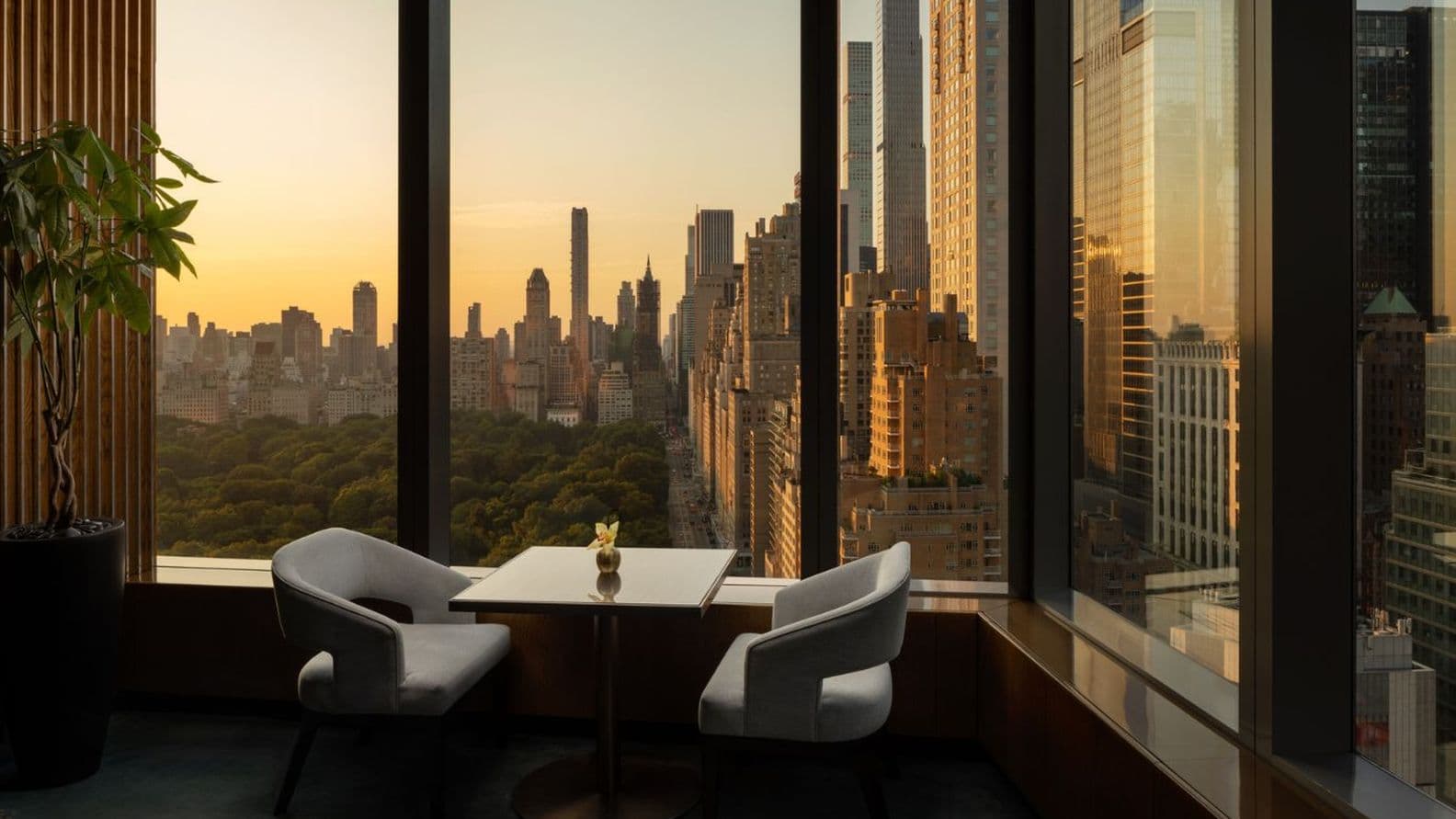 Window seat with table for two, view of the park and skyline in the warm evening light.