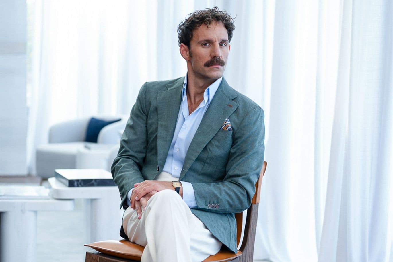 Άνδρας με κοστούμι, κάθεται σε μια καρέκλα