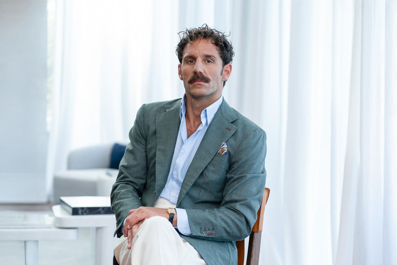 Άνδρας με κοστούμι, κάθεται σε μια καρέκλα