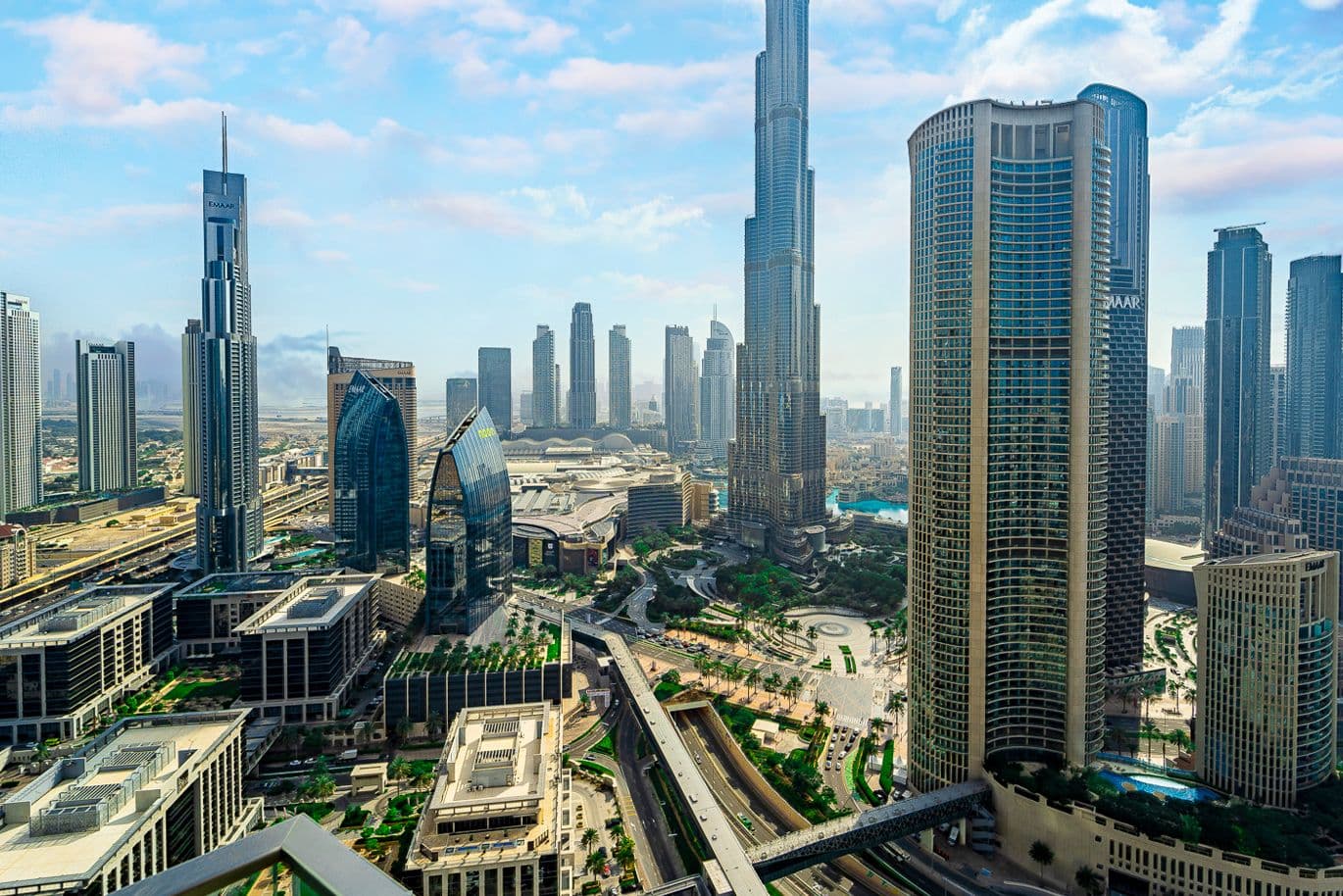 Burj Vista in Dubai showing the Burj Khalifa, landscaped gardens, and surrounding residential buildings.