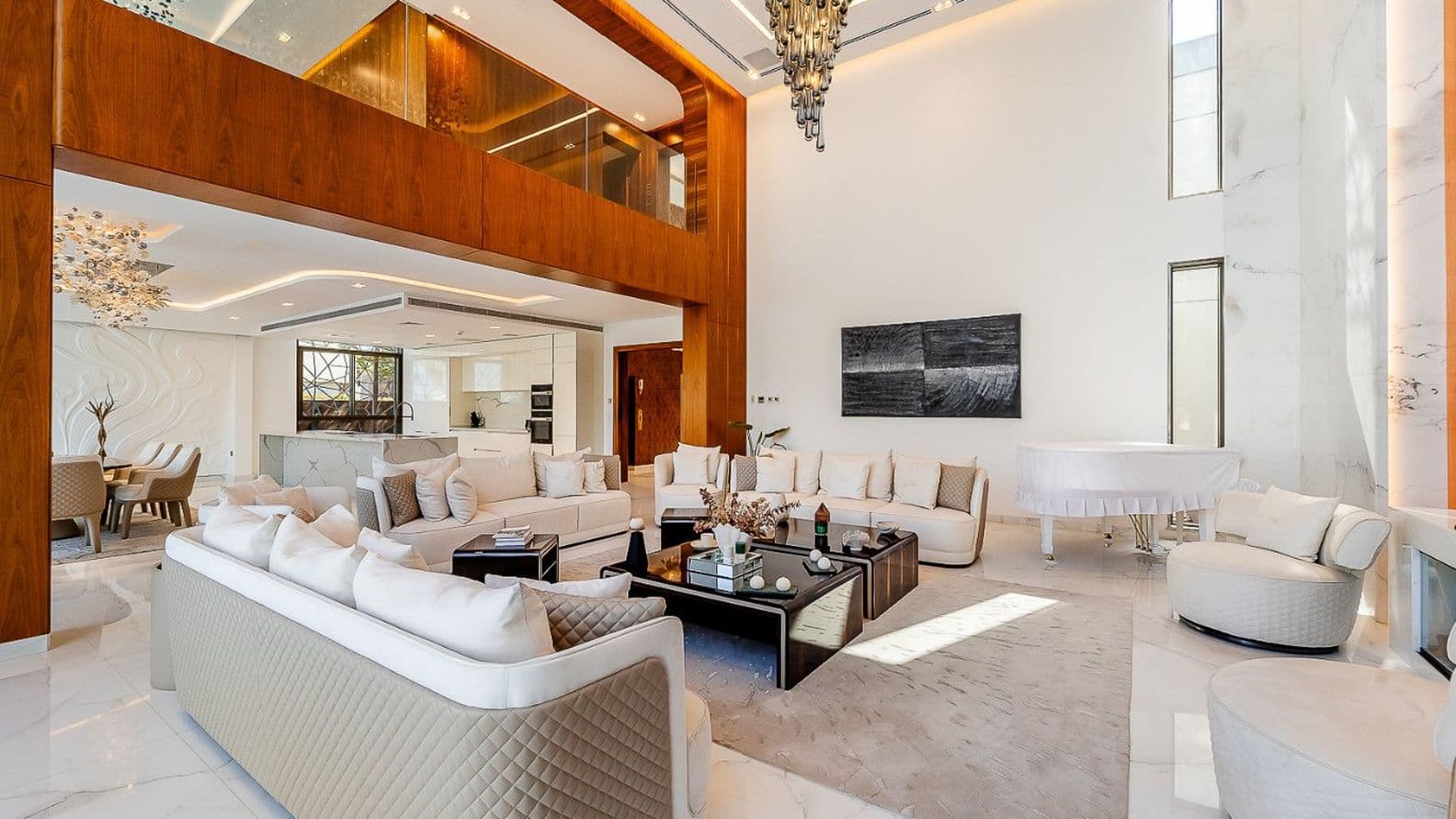 Luxurious modern living room with white sofas, a glass coffee table, a white grand piano, and elegant decor under a high ceiling and large windows.