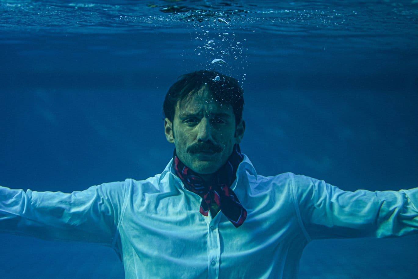Άνδρας με λευκό πουκάμισο μέσα στο νερό