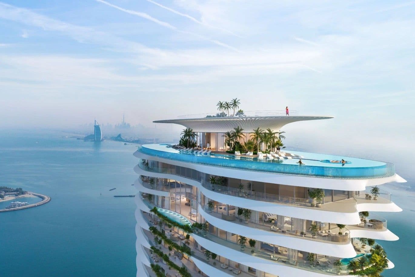 Außenansicht eines modernen, weißen Hochhauses mit einem Pool auf dem Dach mit Blick auf das Meer und die Skyline von Dubai.
