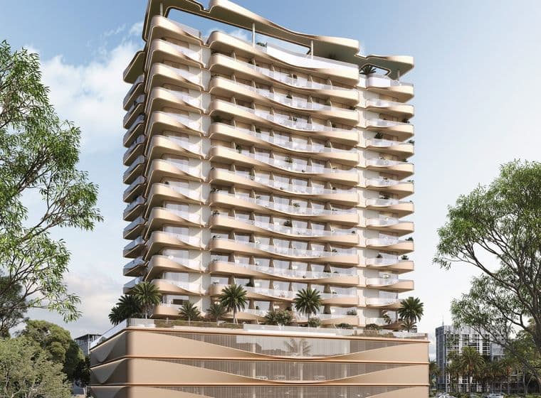 Modern high-rise building with wavy balconies, surrounded by greenery, under a clear blue sky. A car is parked on the road in front.