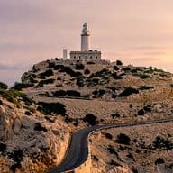 Leuchtturm auf einer felsigen Klippe bei Sonnenuntergang.