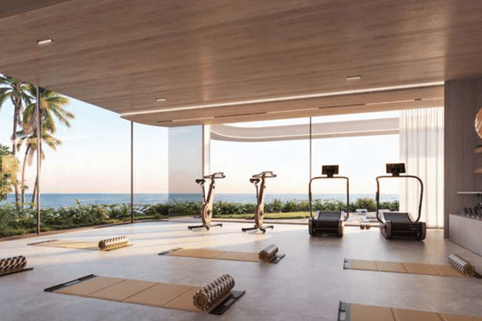 Indoor gym at ELLE Residences with strength and cardio equipment in a contemporary setting.