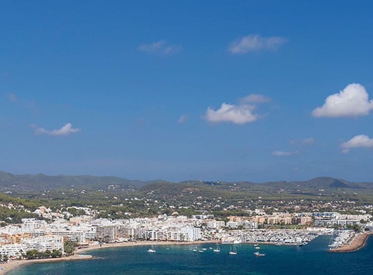 Blick auf eine Küstenstadt mit Gebäuden und dem Strand.